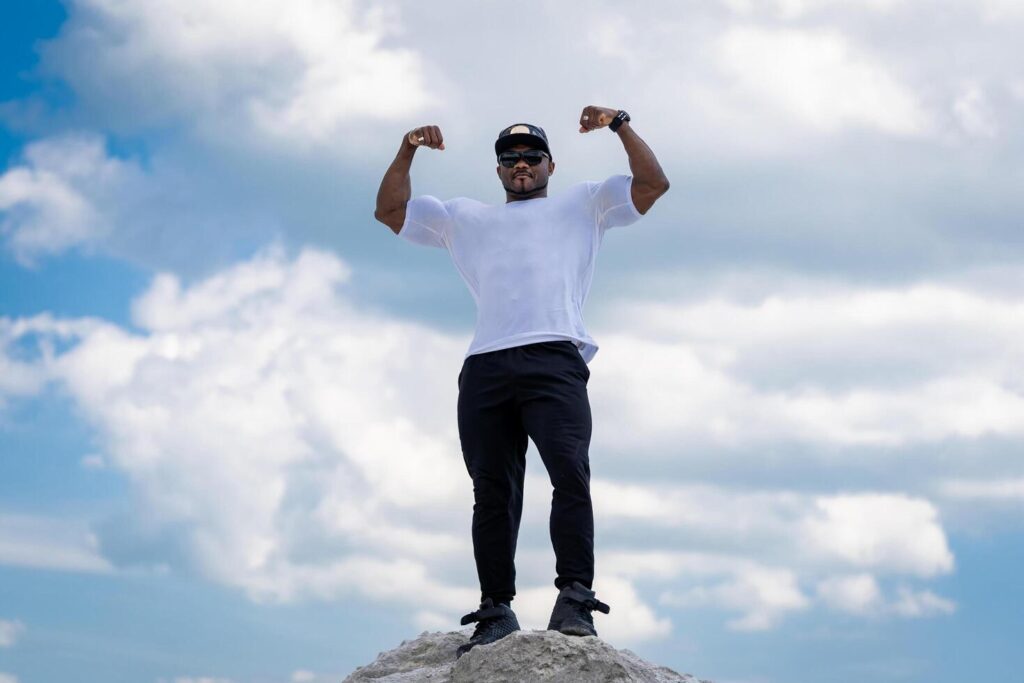 Strong handsome man posing for camera on blue sky. Attractive young lifestyle man. Stock Free