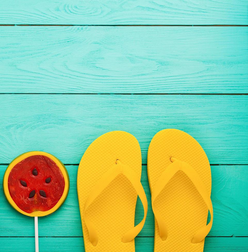 Summer accessories. Flip flops, sunglasses, towel, red cap and oranges on blue wooden background. copy space. Stock Free