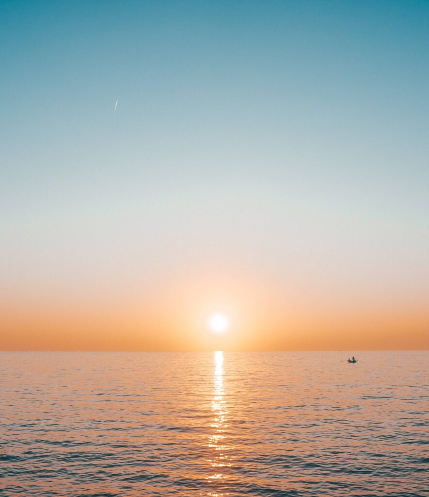 Sunset over the Sea with a Small Boat Free Photo