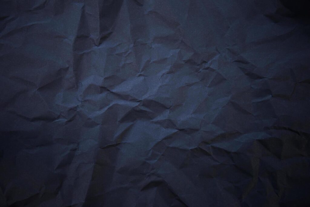 Textured crumpled black paper background. Free Photo