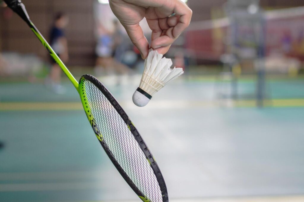 The badminton player holding a white shuttlecock and racket Stock Free