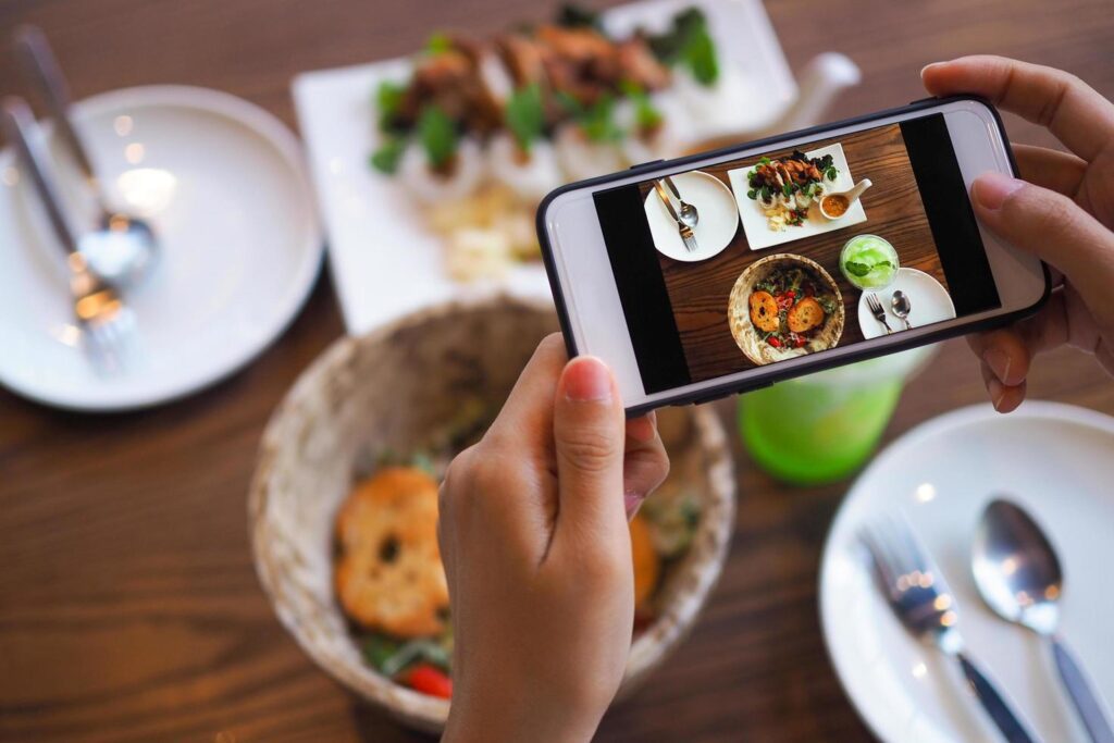 The hand of a woman take pictures of food made by herself. Food sellers take photo with a smartphone to post on the online food ordering website. Stock Free