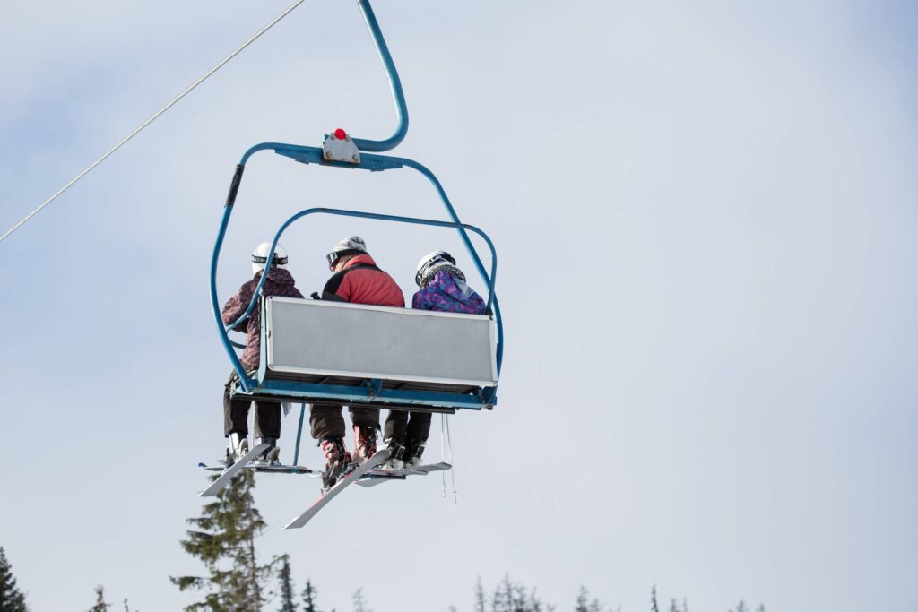 Three Skiers on Ski Lift Free Photo