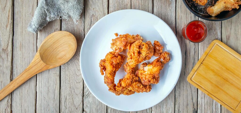 Top view of Fried chicken food and Fried Chicken Drumsticks wite french fries and tomato ketchup on a wooden table Stock Free