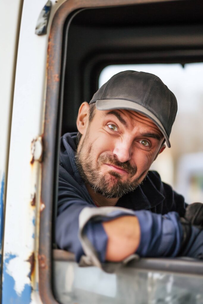 Truck Driver Making Faces Out of the Truck Window Stock Free