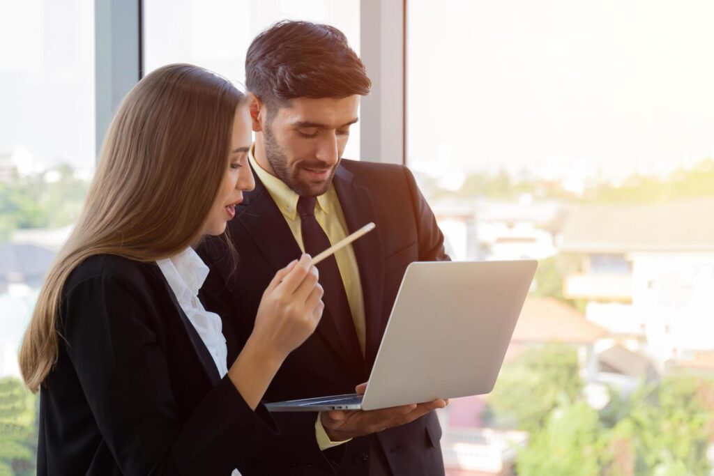
									Two business men and women were neatly dressed in a suit and tie standing meeting beside the glass wall in the office. Stock Free