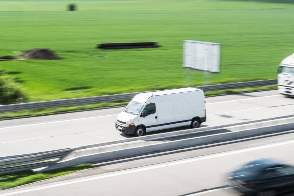 White Delivery Van in Motion Driving on Highway Free Photo