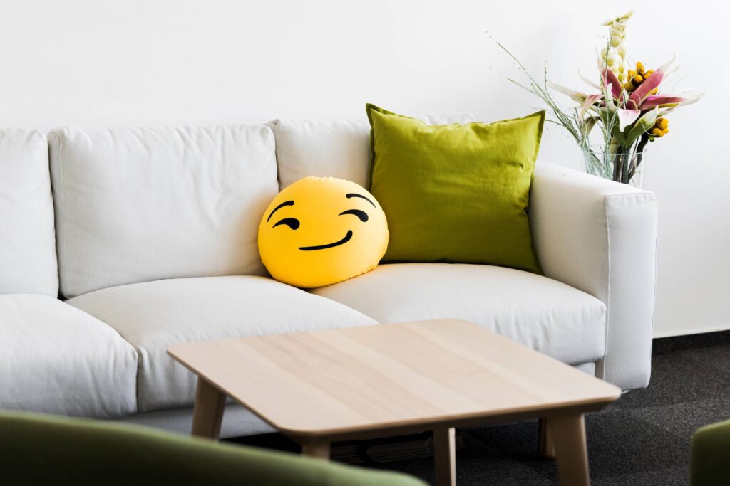 White Office Couch with Funny Emoji Pillow Free Photo