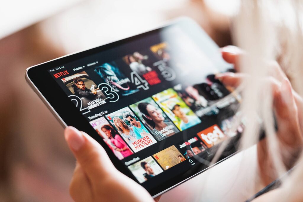 Woman Browsing Netflix App with Movies on Her Tablet Free Photo