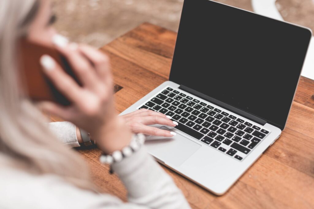 Woman Calling While Working Remotely on Laptop Free Photo