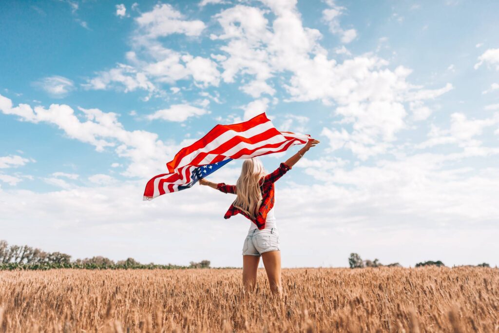 Woman Celebrating Independence Day with Big American Flag Free Photo