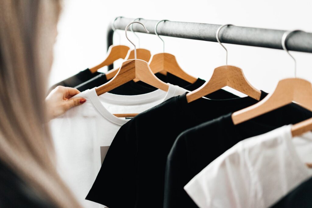 Woman Choosing T-Shirts During Clothing Shopping at Apparel Store Free Photo