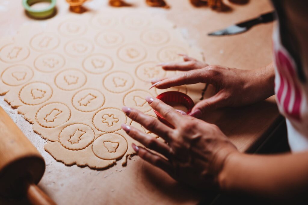 Woman Cutting Out Christmas Cookies Free Photo