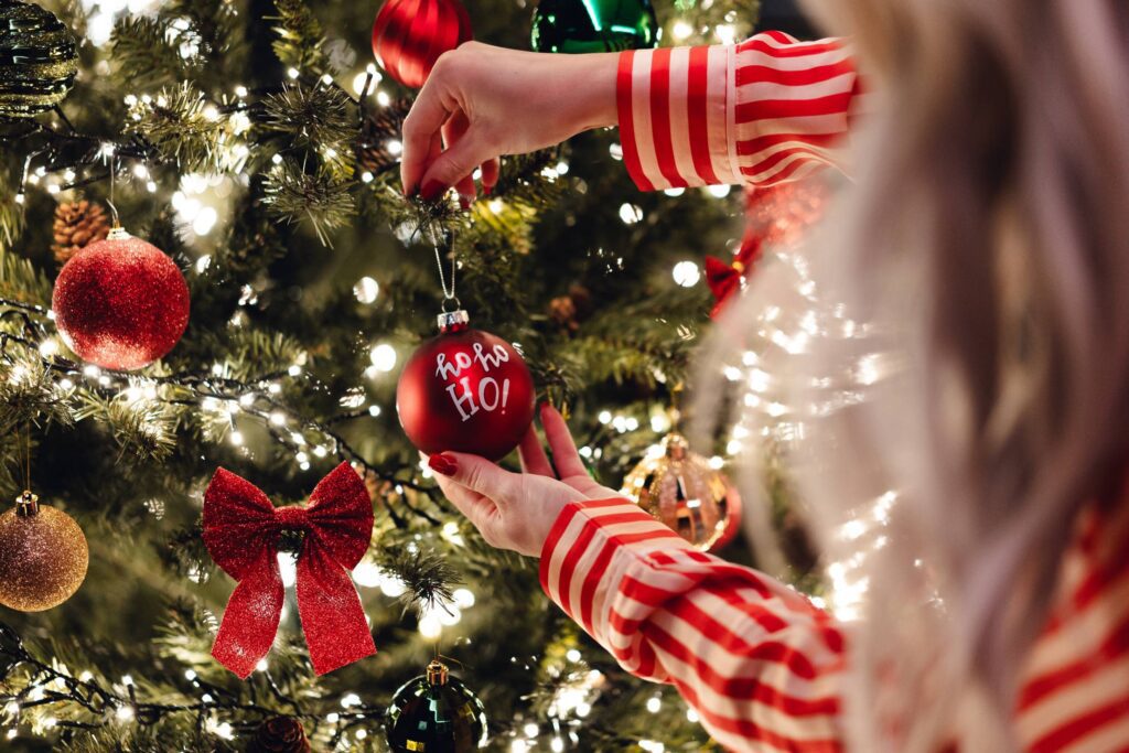 Woman Decorating a Christmas Tree with Christmas Tree Balls Free Photo