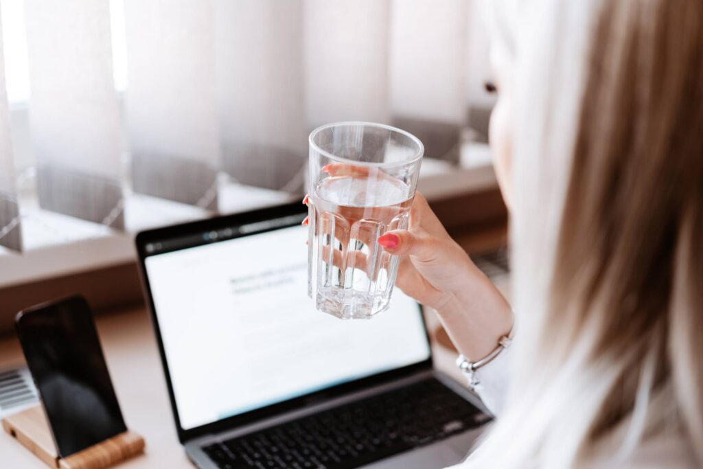 Woman Drinking Still Water at Work Free Photo