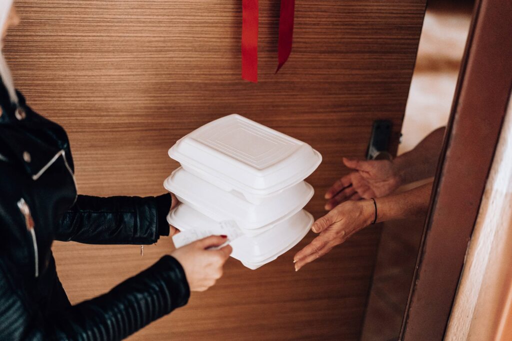 Woman Handing over Ordered Boxes with Food Free Photo