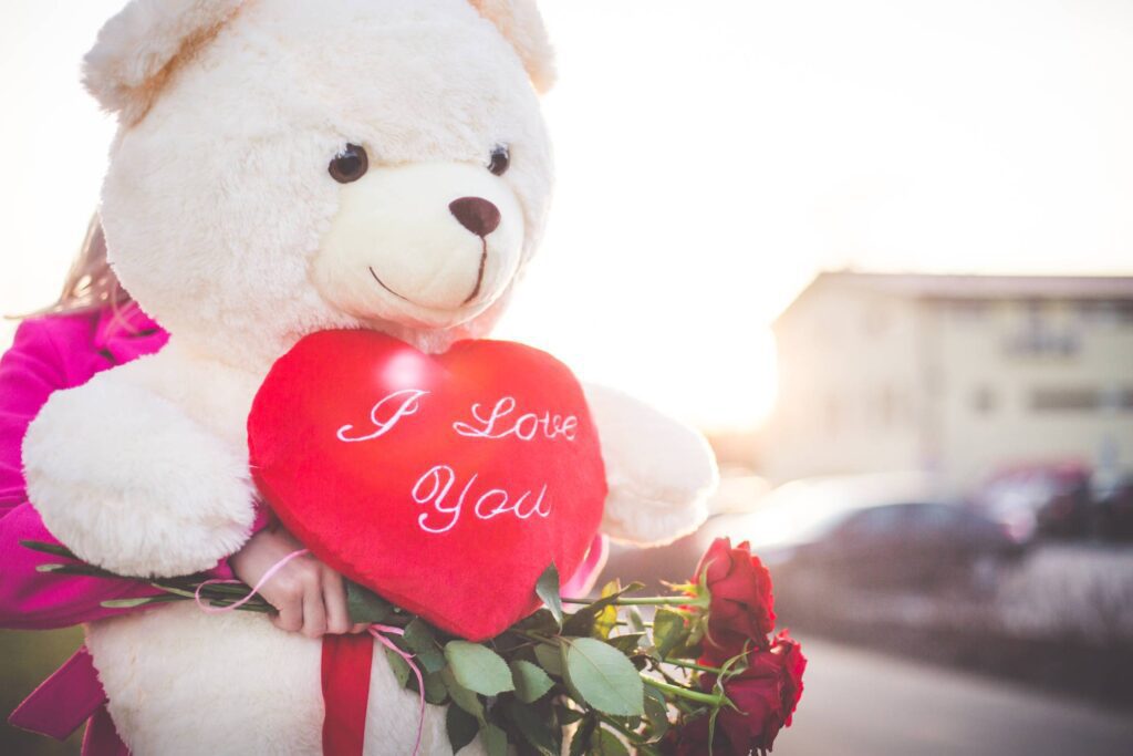 Woman Holding a Big Teddy Bear and Roses on Valentine’s Day Free Photo