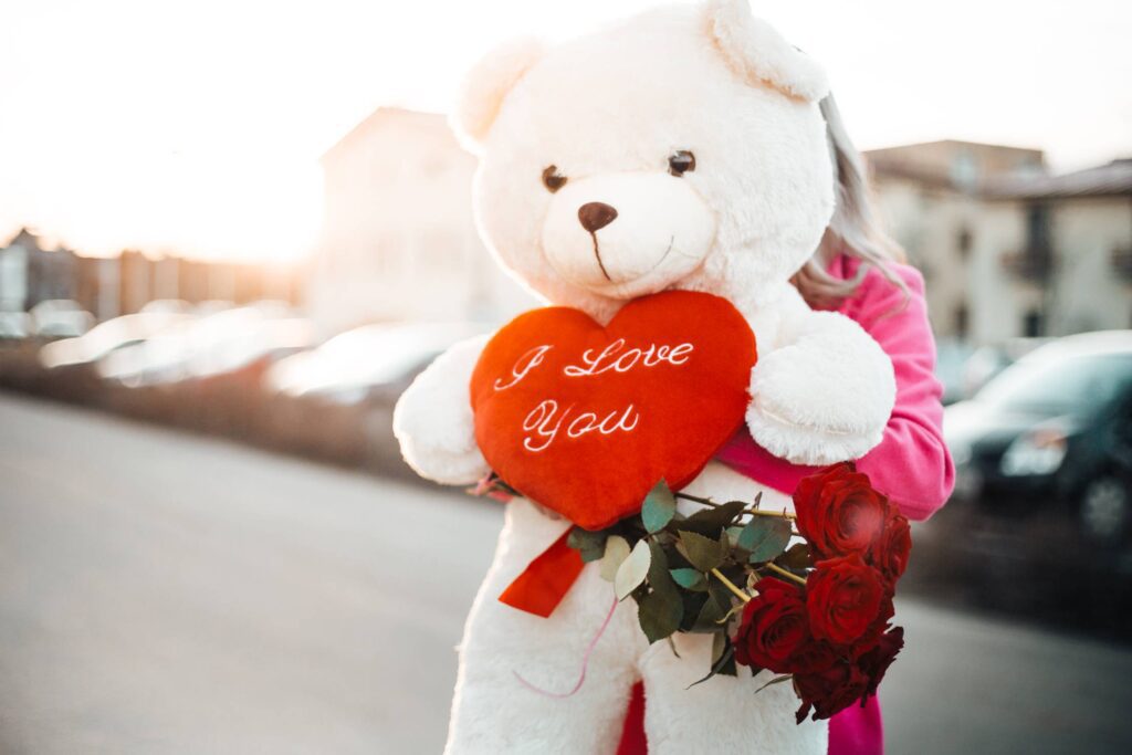 Woman Holding a Big Teddy Bear with I Love You Heart Free Photo