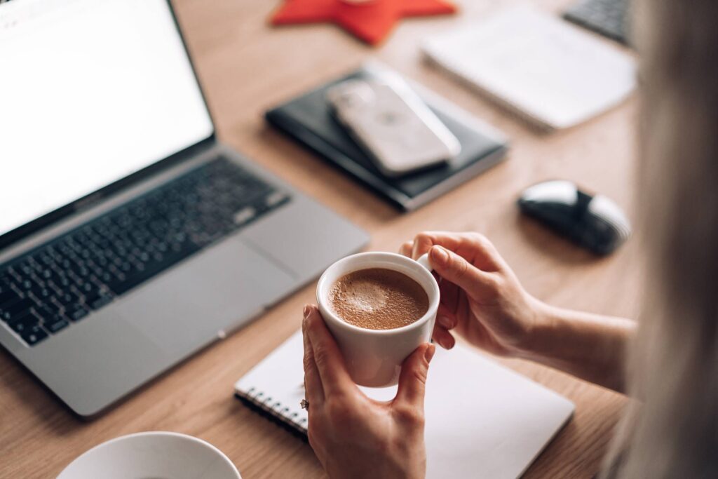 Woman Holding a Cup of Coffee at Work Home Office Free Photo