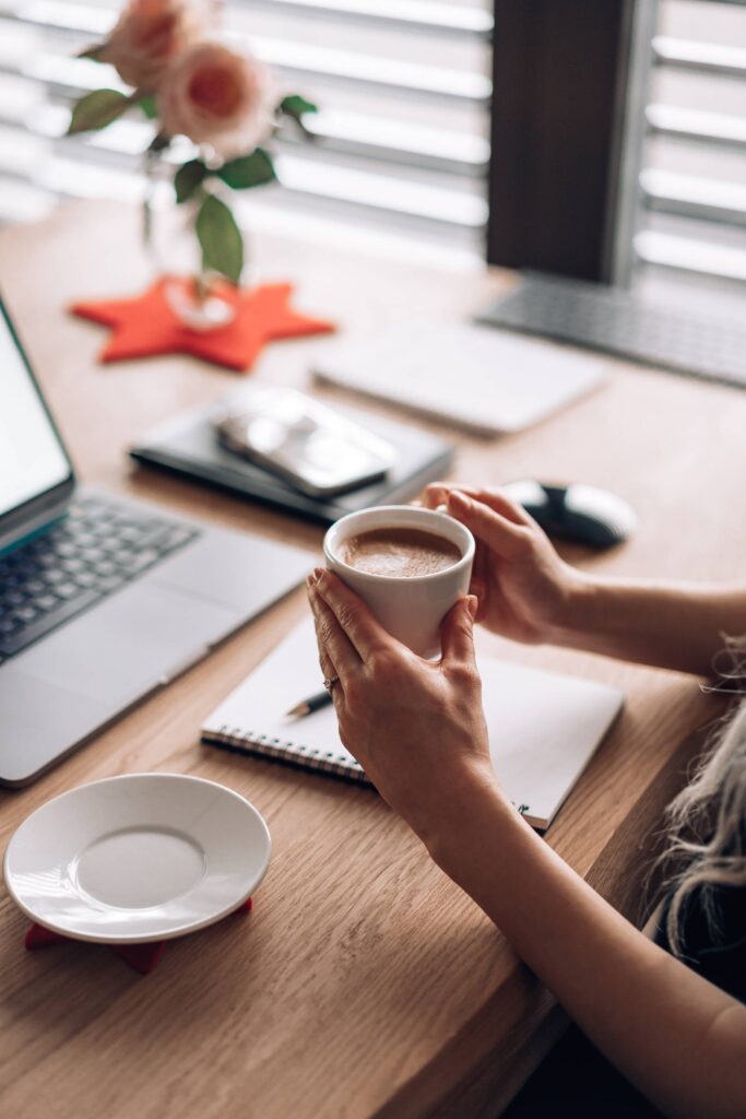 Woman Holding a Cup of Coffee in Her Home Office Free Photo