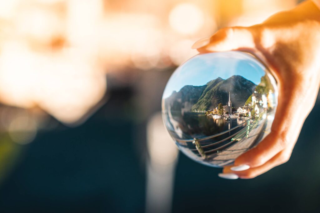 Woman Holding a Glass Ball with Reflection of Hallstatt Village Free Photo