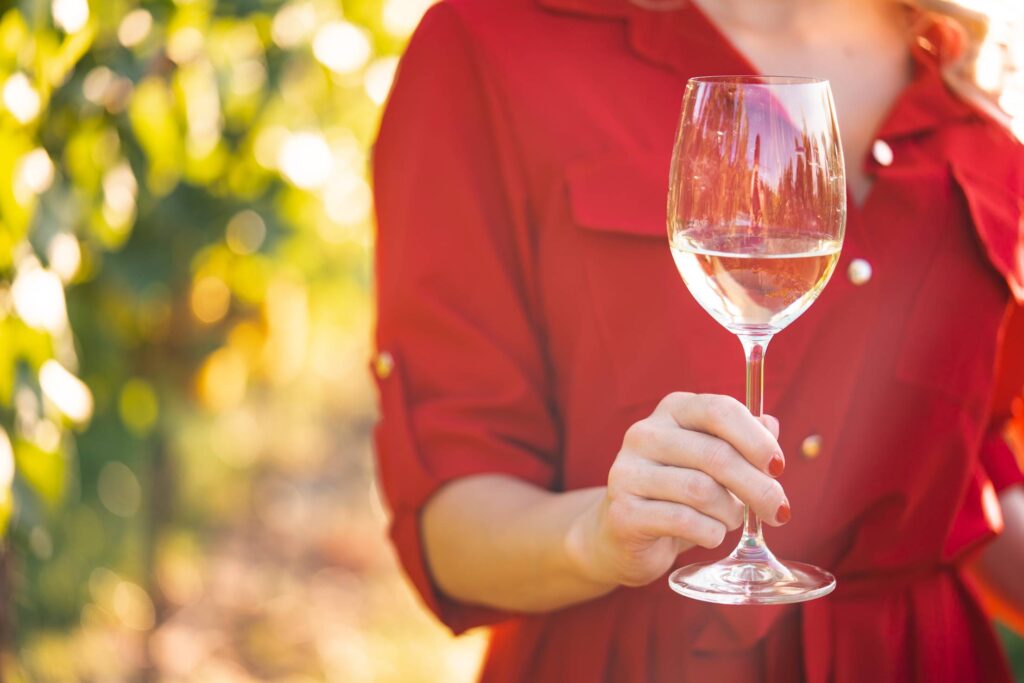 Woman Holding a Glass of Wine in a Vineyard Free Photo