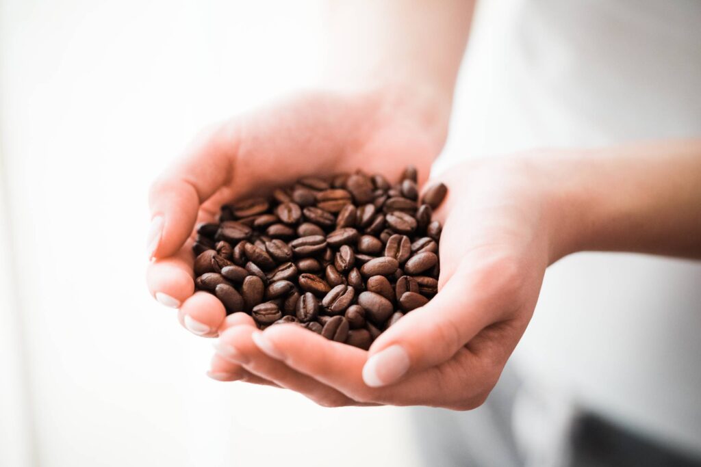 Woman Holding a Handful of Coffee Beans Free Photo