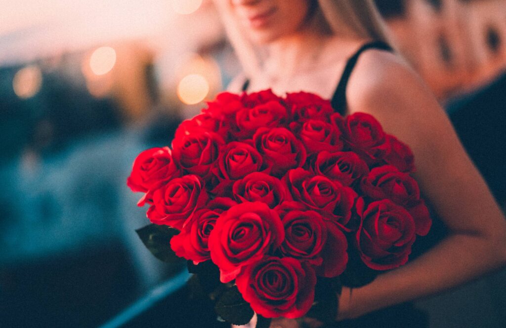 Woman Holding a Large Bouquet of Red Roses Free Photo