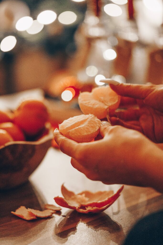 Woman Holding a Peeled Tangerine in Her Hands Free Photo