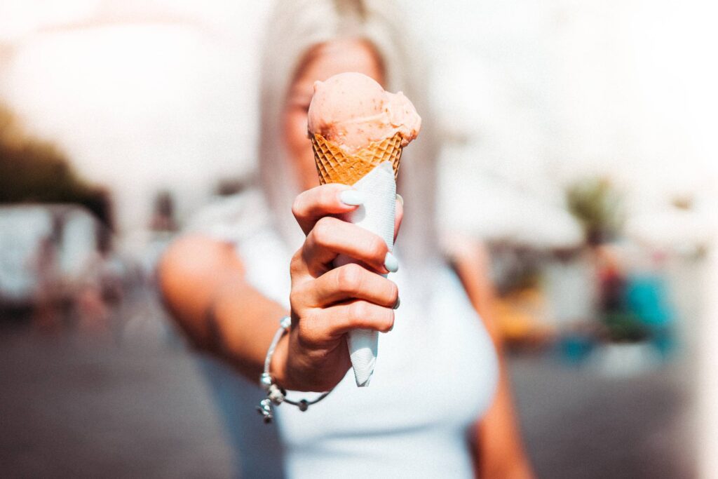 Woman Holding an Ice Cream in Front of Her Face Free Photo