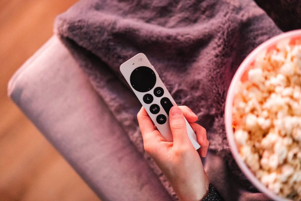 Woman Holding Apple TV Remote Control Free Photo