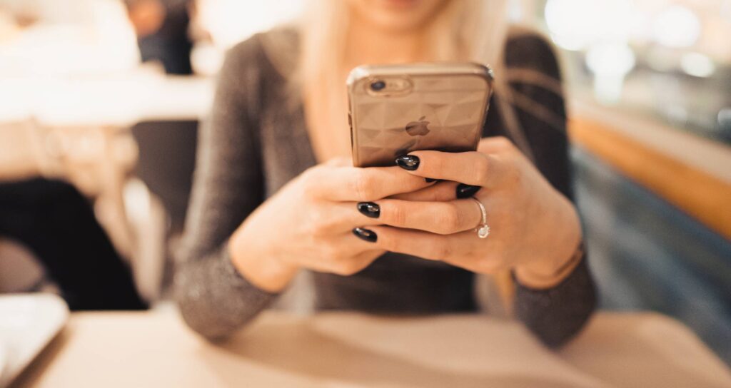 Woman Holding iPhone in Her Hands Free Photo