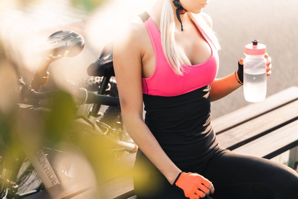 Woman in a Cycling Dress Holding a Bottle of Water Free Photo