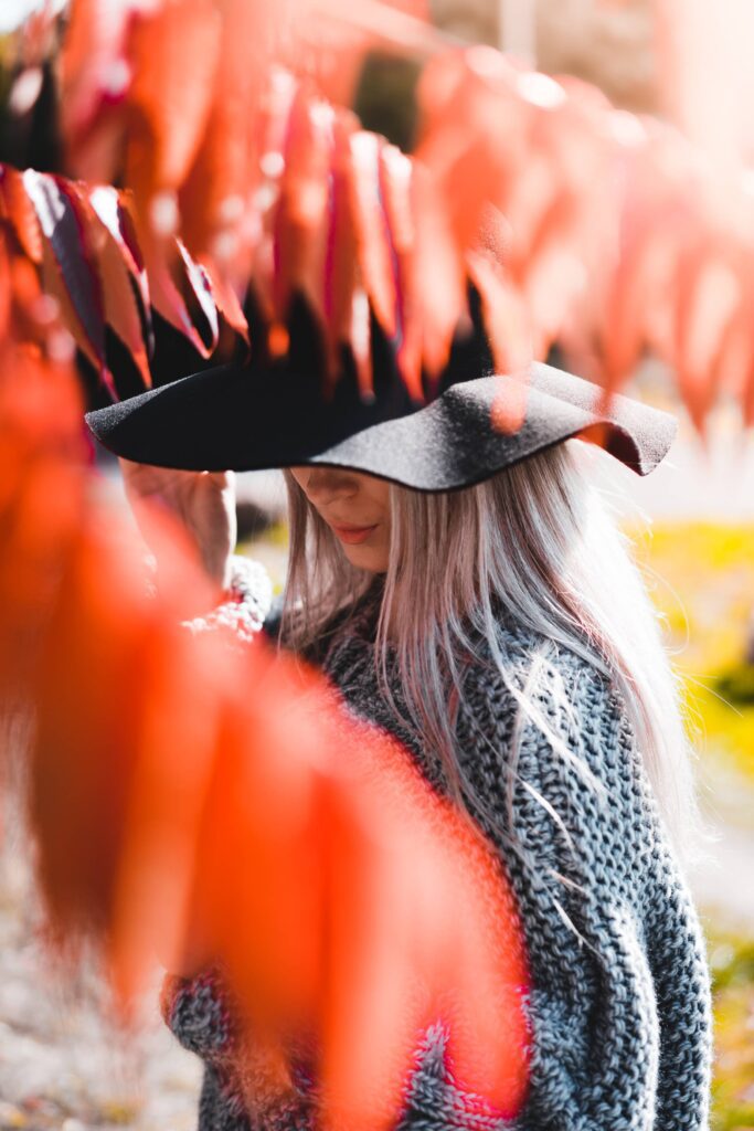 Woman in a Hat Hiding Behind The Tree Branches Free Photo