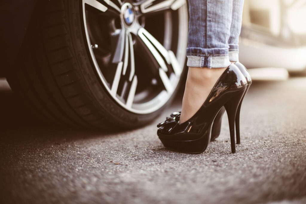 Woman in Black High Heels Standing Next to a Car Free Photo