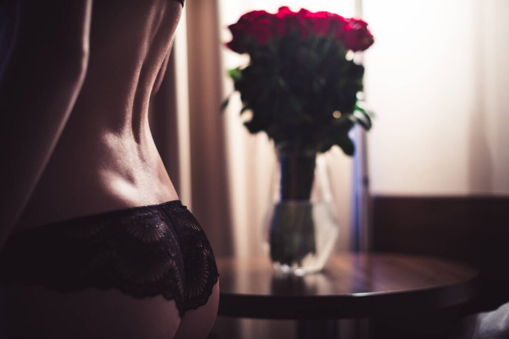 Woman in Lingerie with Bouquet of Roses on a Romantic Date Free Photo