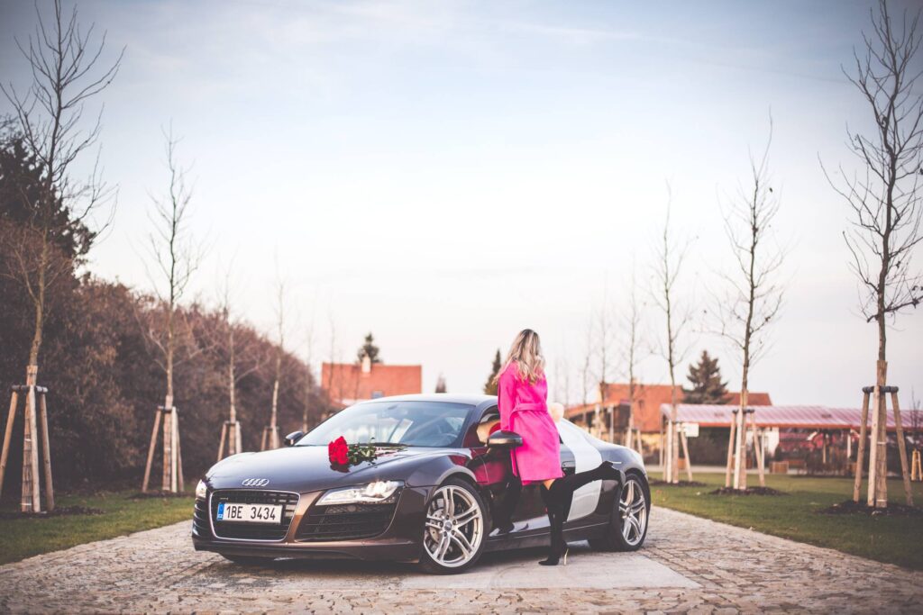 Woman in Pink Coat Standing Next To a Supercar Free Photo