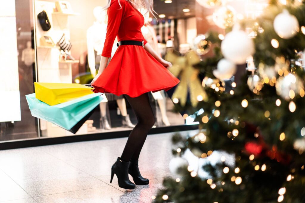 Woman in Red Dress Enjoying Christmas Shopping Free Photo