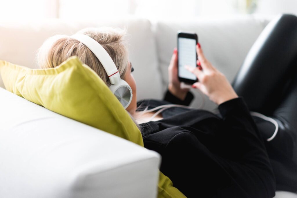 Woman Listening to Music on a Sofa Free Photo