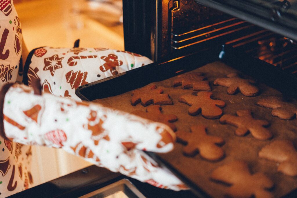 Woman Putting Christmas Cookies in The Oven Free Photo