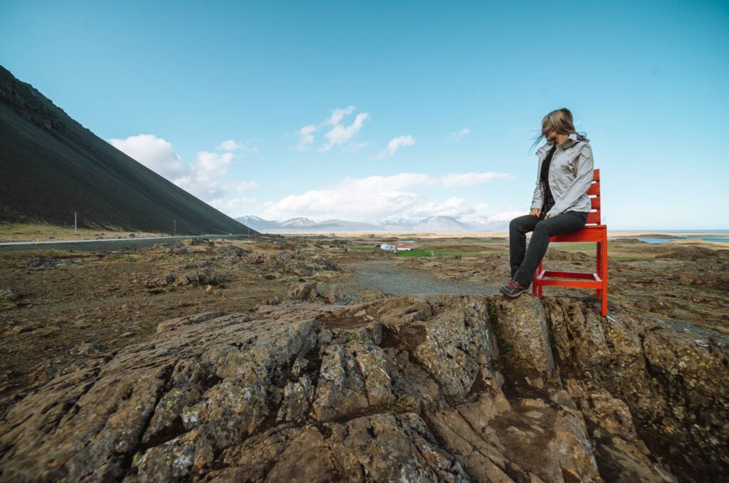 Woman Sitting on a Big Red Chair in Iceland Free Photo