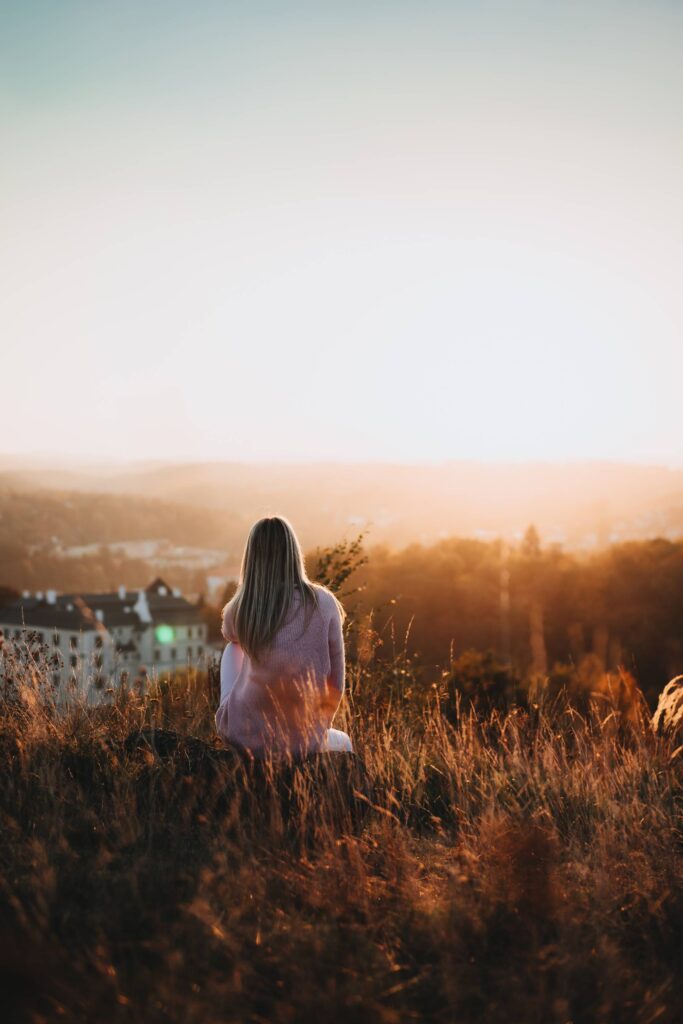 Woman Sitting on a Hill and Looking at The Castle Free Photo