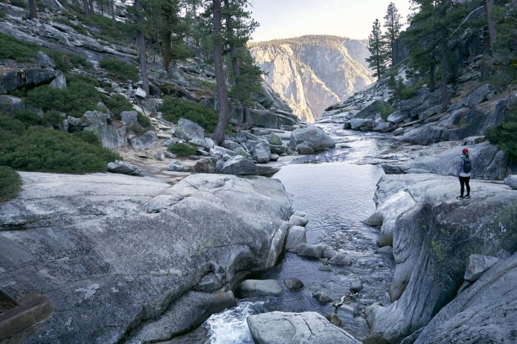 Woman Standing near the Top of the Waterfall in Yosemite National Park Free Photo