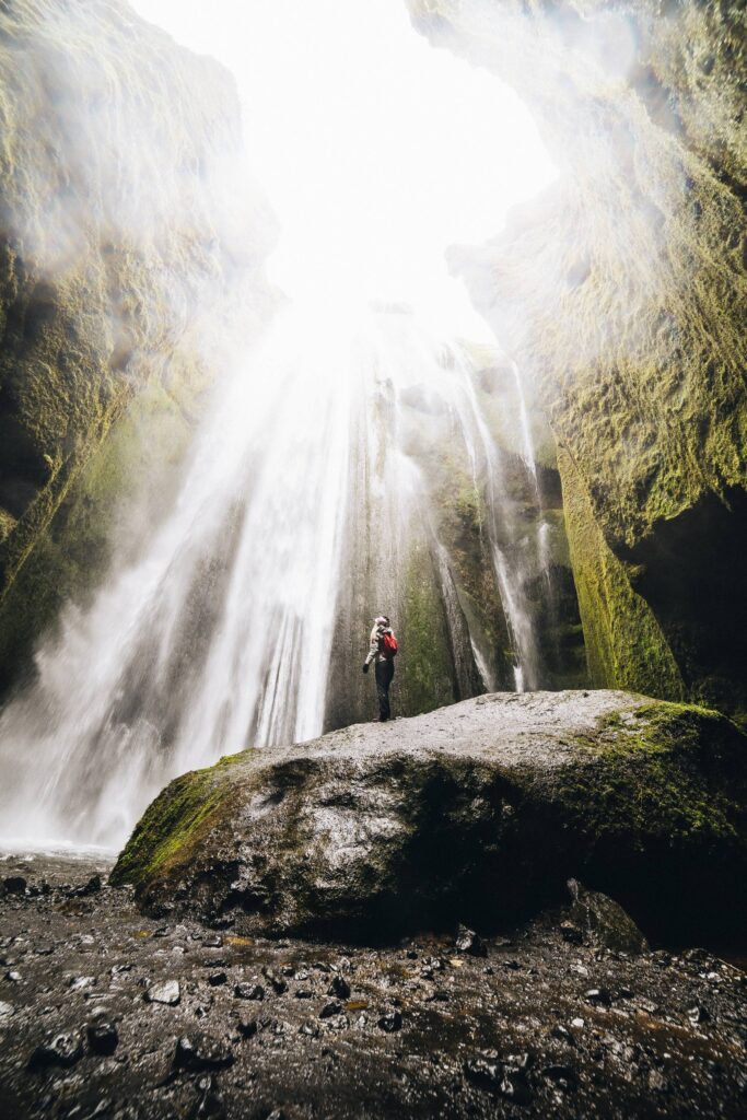 Woman Standing Under The Gljúfrabúi Waterfall, Iceland Free Photo