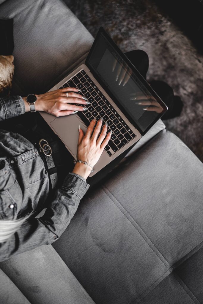 Woman Typing on Her Laptop on a Sofa Free Photo