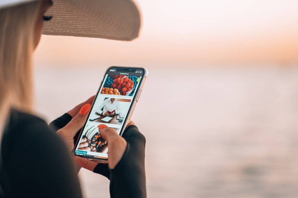 Woman Using Smartphone During Golden Hour by the Sea Free Photo