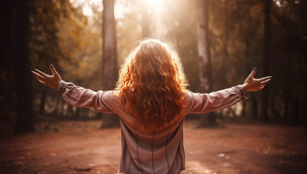 Woman Welcoming New Day with Open Arms in Nature Free Photo