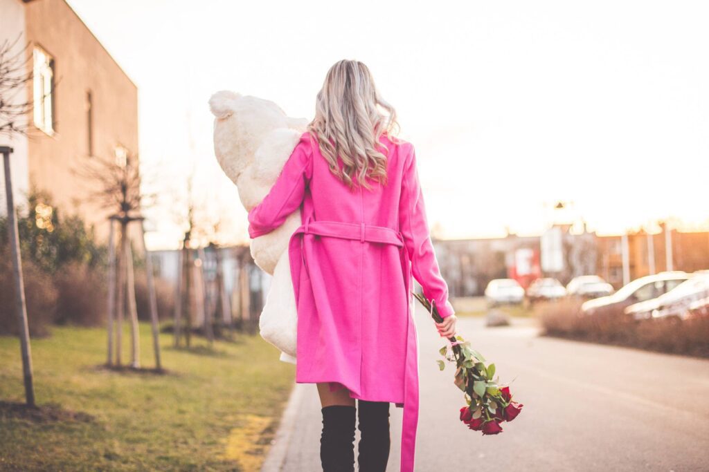 Woman with Big Teddy and Roses Walking on the Street Free Photo