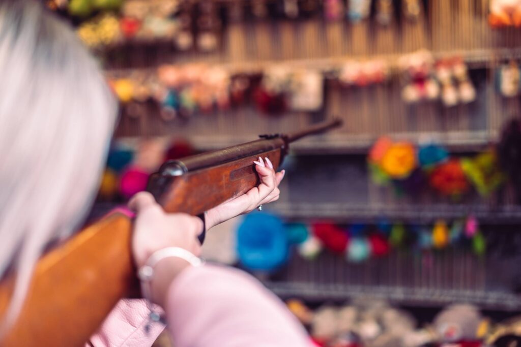 Woman with Rifle at Fun Fair Shooting Range Free Photo