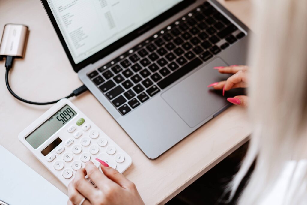 Woman Working on a Laptop and Calculator Free Photo